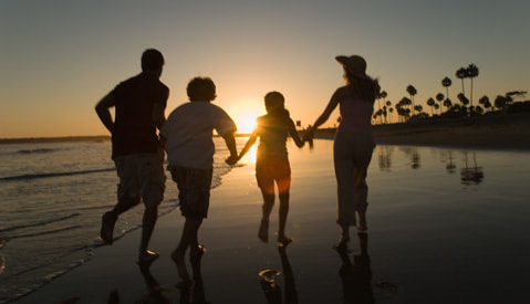 family running on the beach